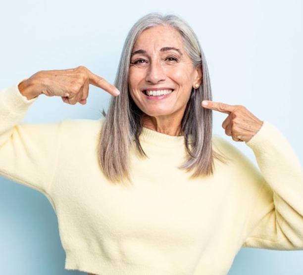 Mature woman pointing at her smile
