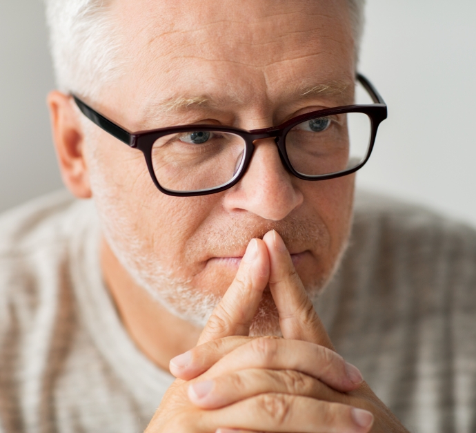 Senior man with glasses looking pensive