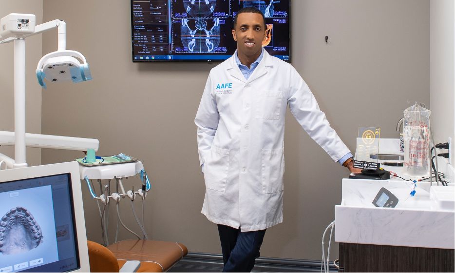 Staten Island oral surgery dentist Doctor Admasu Gizachew smiling in treatment room