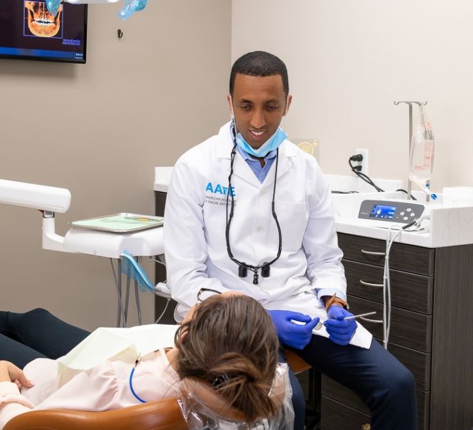 Doctor G talking with a patient sitting in the dental chair