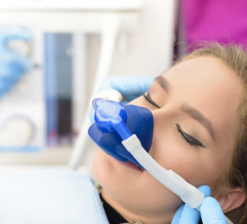 Young woman in dental chair with nitrous oxide sedation mask on her face