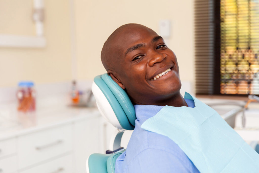 patient smiling after visiting dentist for dental emergency